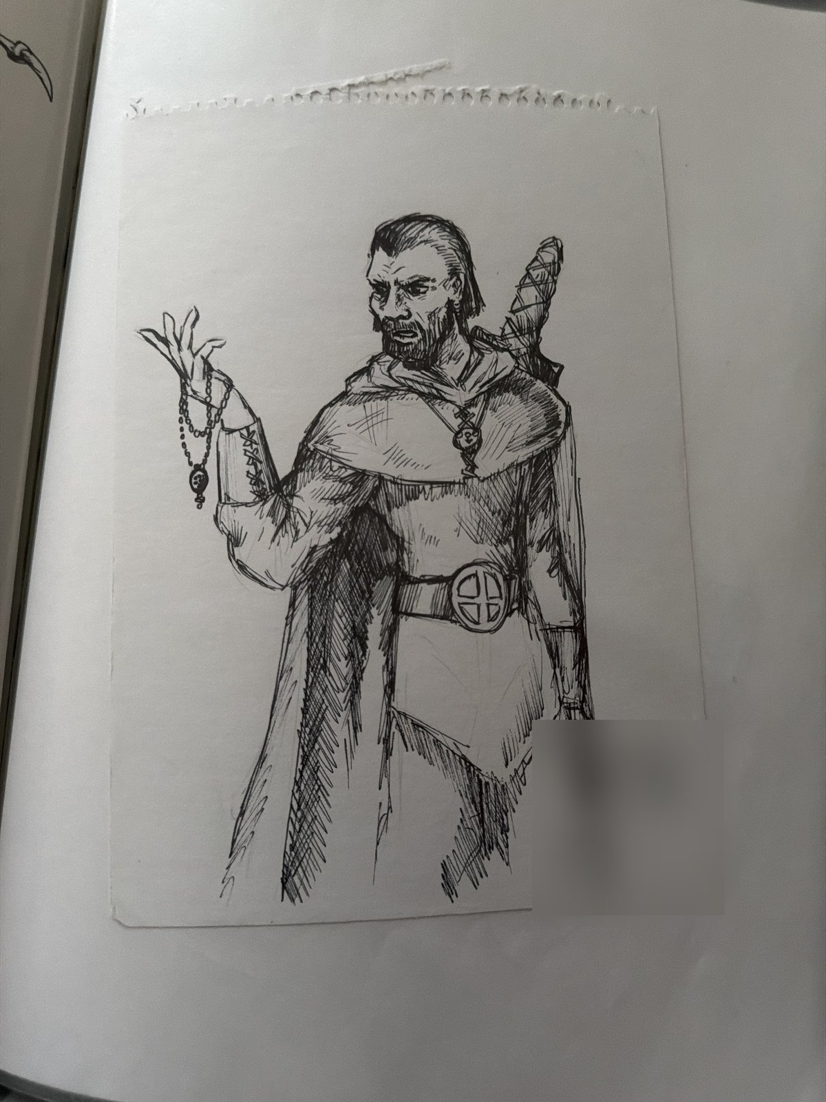 A pen drawing from the 1990s of a bearded man in a cloak holding prayer beads. The artist's name is blurred.